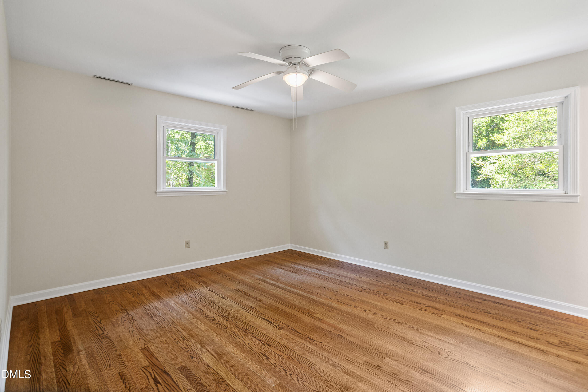 4711 Tanglewood Drive Raleigh, NC 27612 - Photo 23 of 39 a view of an empty room with wooden floor and a window