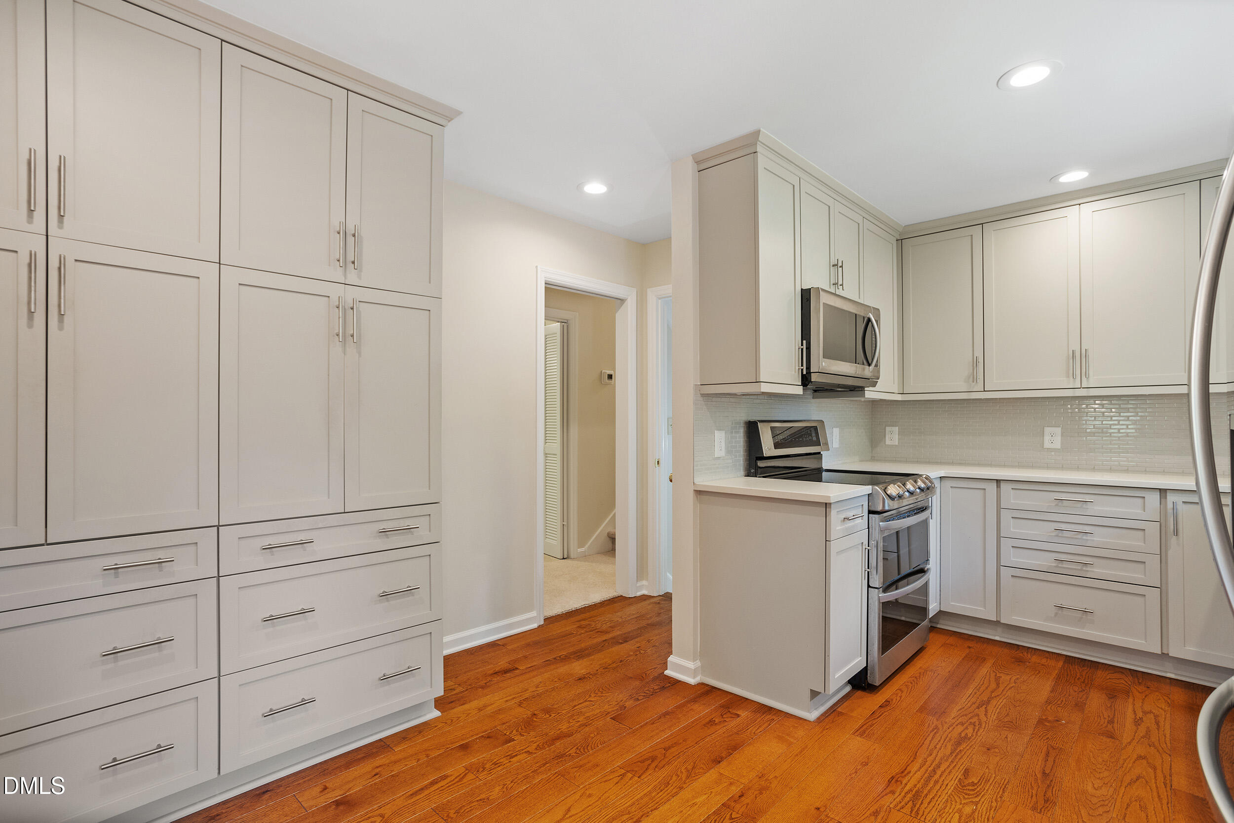 4711 Tanglewood Drive Raleigh, NC 27612 - Photo 2 of 39 a kitchen with granite countertop white cabinets and stainless steel appliances