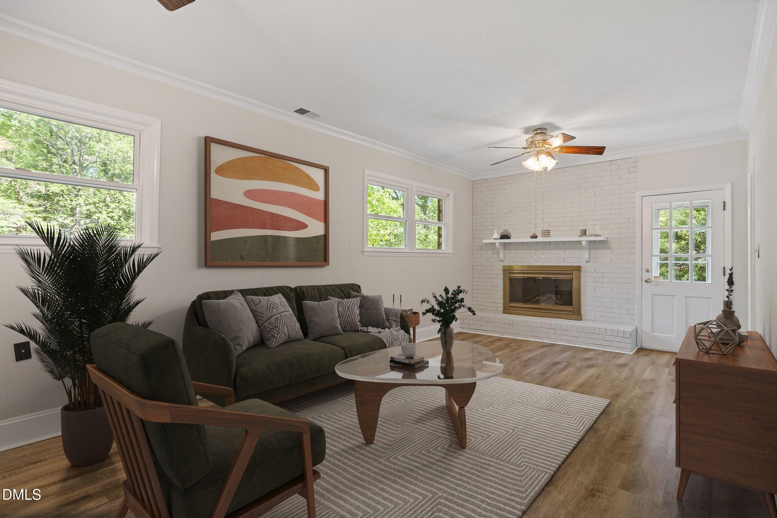 4711 Tanglewood Drive Raleigh, NC 27612 - Photo 5 of 39 a living room with furniture a fireplace and a flat screen tv