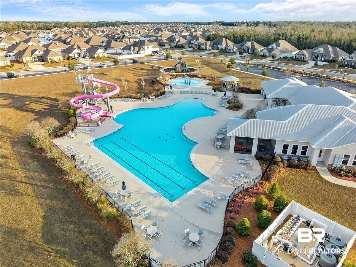 23641 Unbridled Loop Daphne, AL 36526 - Photo 34 of 40 Expansive community pool area featuring a large freeform swimming pool with lap lanes, a separate water play area, and a pink spiral water slide