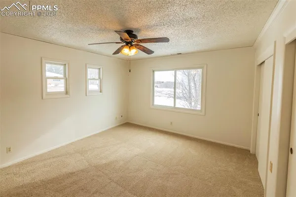 a view of a room with a ceiling fan and closet area