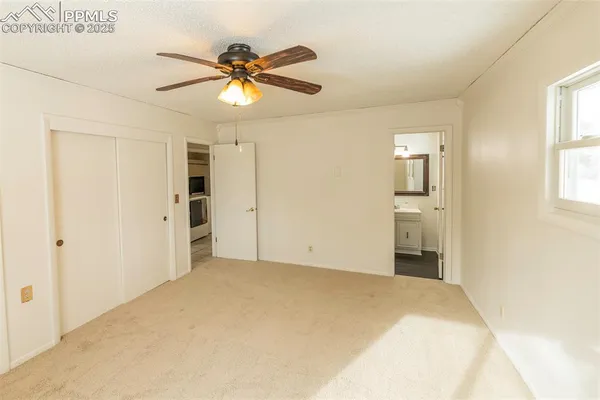 a view of a room with a ceiling fan and a window