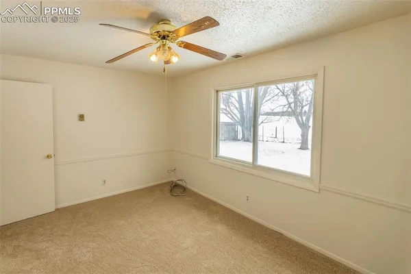 a view of a room with a ceiling fan