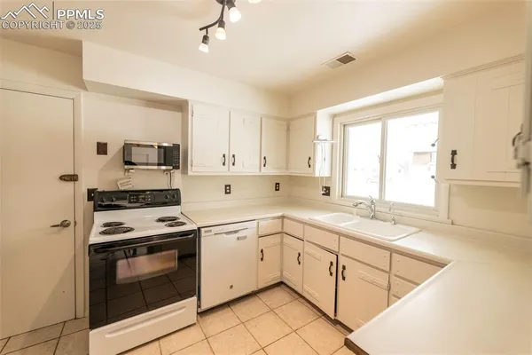 a kitchen with a sink a stove and cabinets