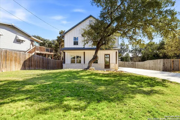 a view of a house with backyard and a tree