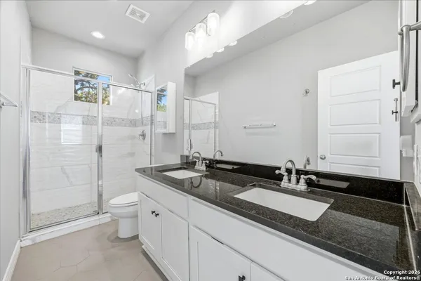 a bathroom with double sink and a mirror