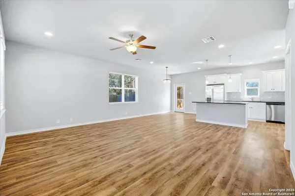 a view of an empty room with window and wooden floor