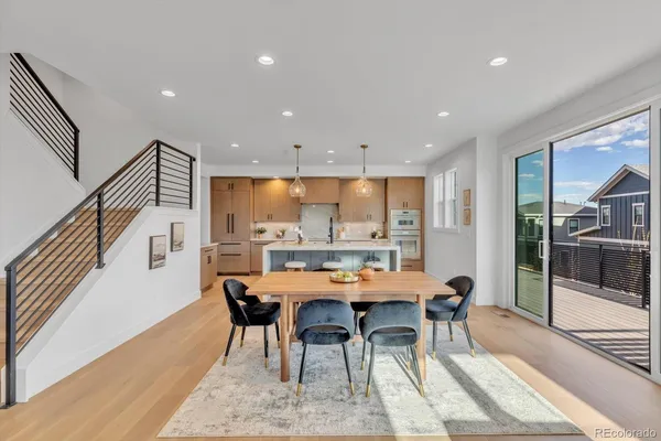 a kitchen with kitchen island granite countertop a table chairs sink and cabinets