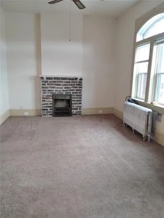 an empty room with fireplace and windows