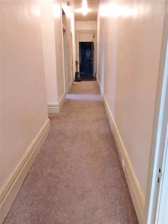 a view of a hallway with wooden shelves