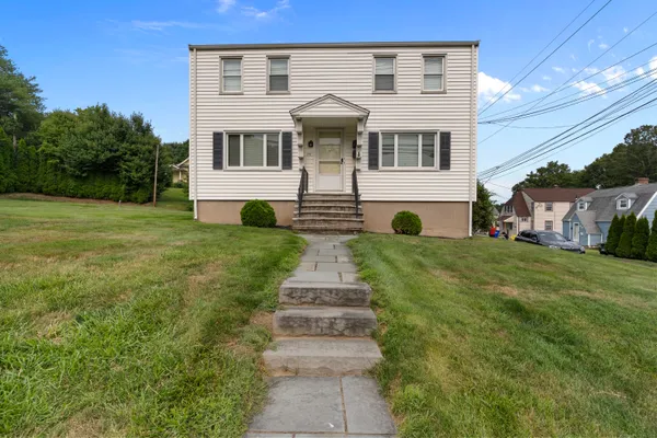 a front view of a house with a garden