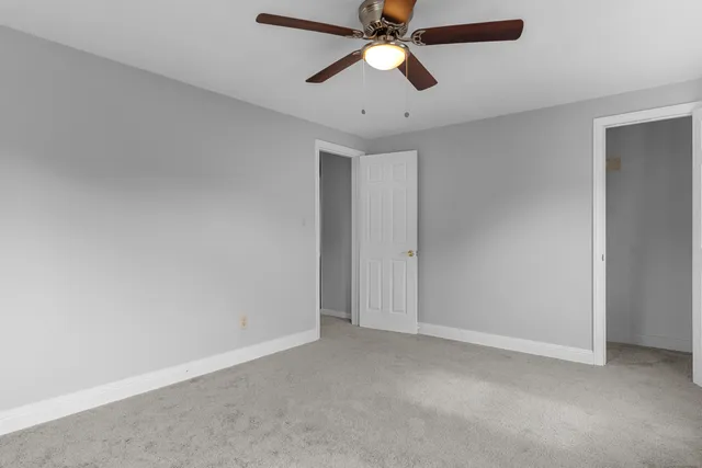 an empty room with a fan and a fan