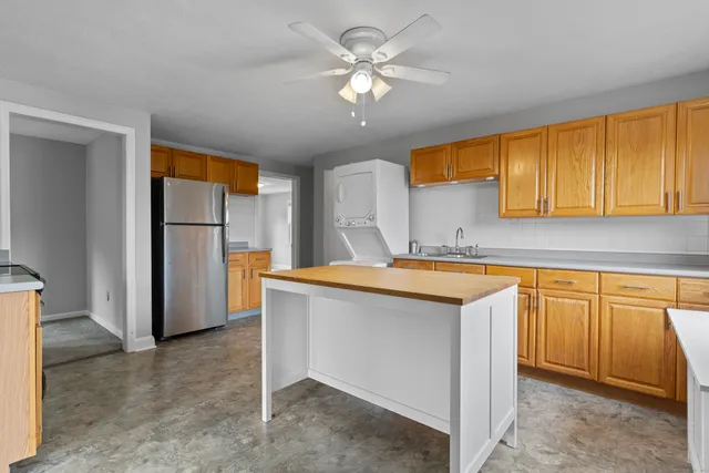 a kitchen with stainless steel appliances granite countertop a refrigerator a sink dishwasher and a stove with cabinets