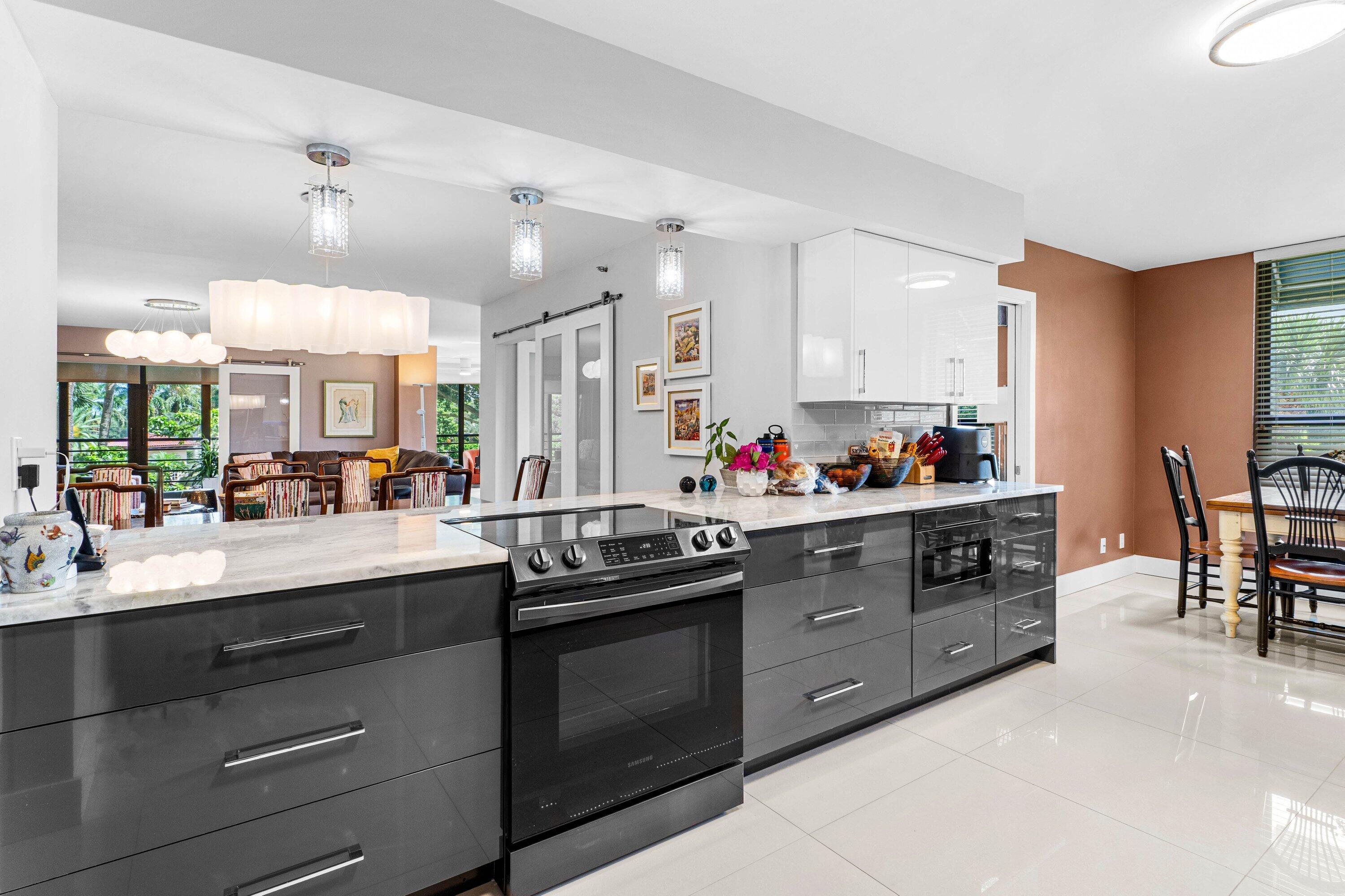 7572 Regency Lake Drive, Unit 301 Boca Raton, FL 33433 - Photo 13 of 38 a kitchen with a sink stove and cabinets