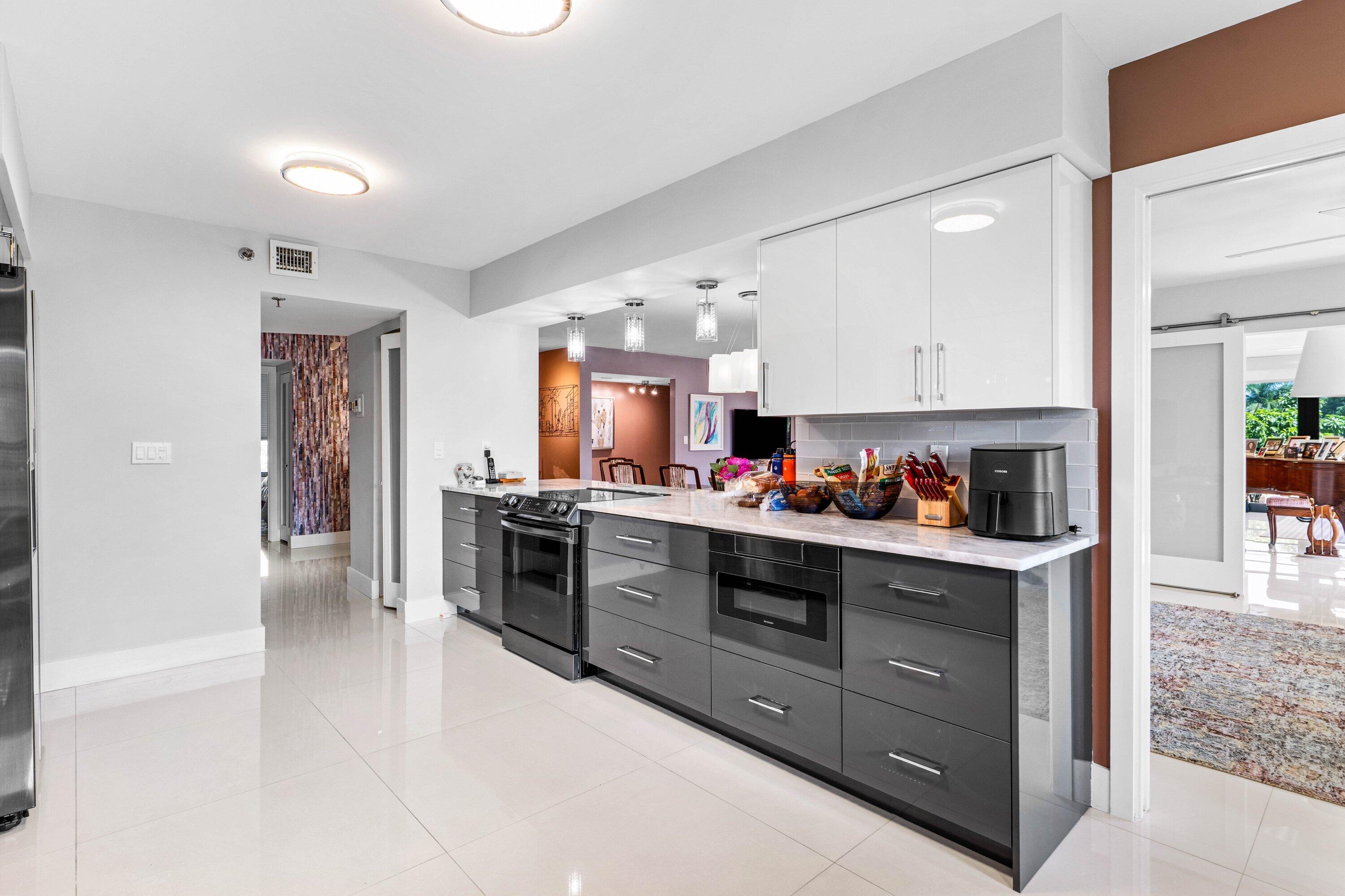 7572 Regency Lake Drive, Unit 301 Boca Raton, FL 33433 - Photo 16 of 38 a kitchen with stainless steel appliances granite countertop a stove and a sink