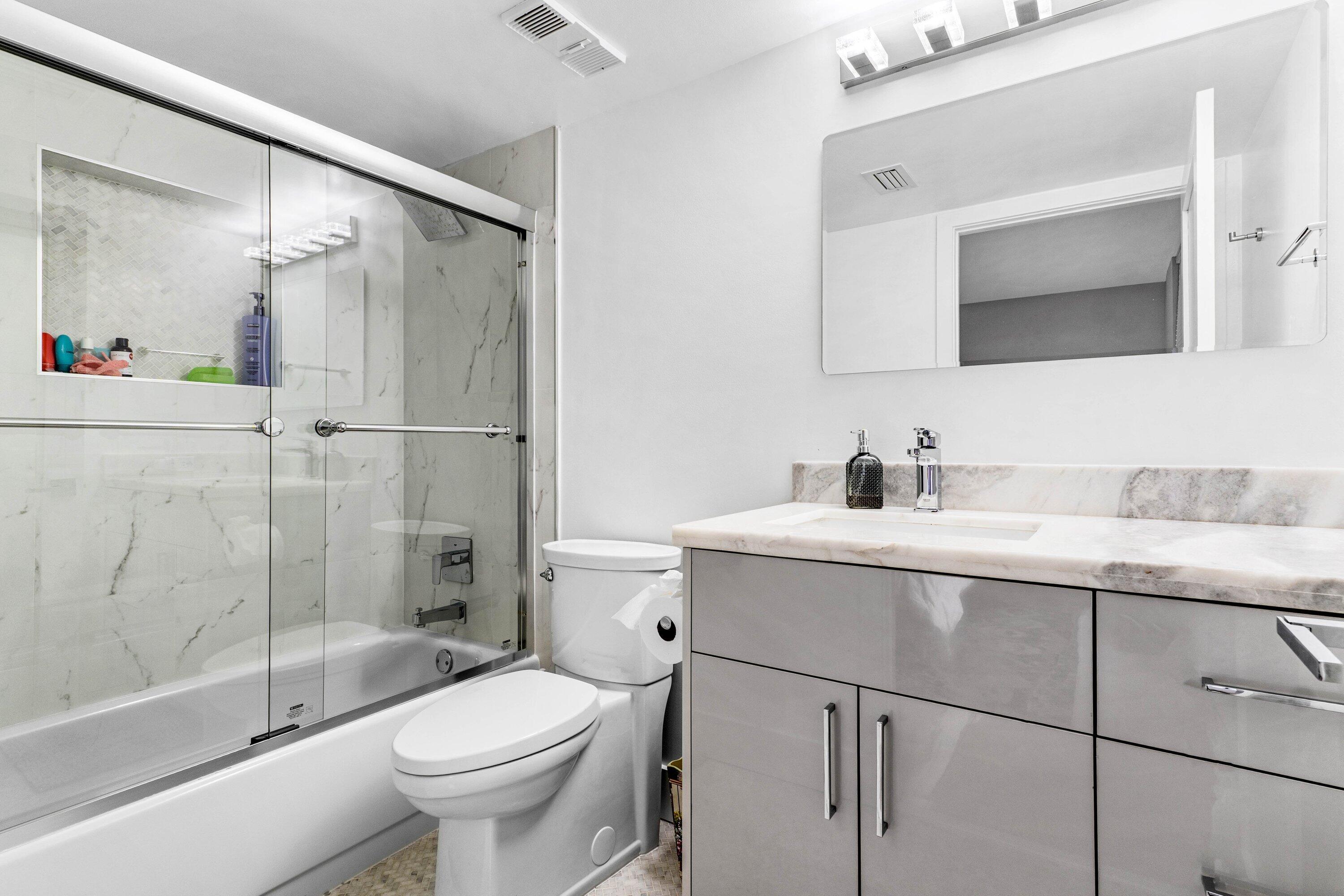 7572 Regency Lake Drive, Unit 301 Boca Raton, FL 33433 - Photo 19 of 38 a bathroom with a sink toilet and shower