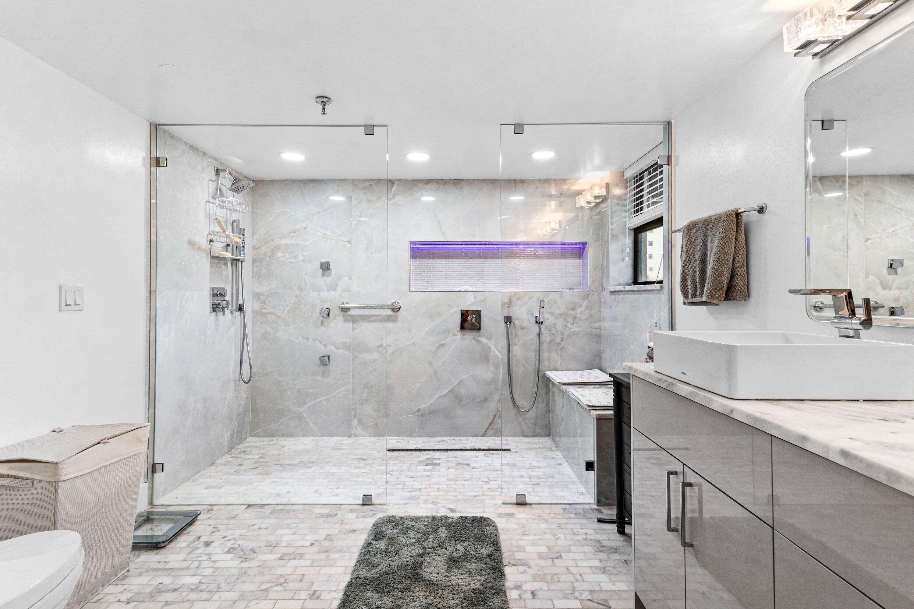 7572 Regency Lake Drive, Unit 301 Boca Raton, FL 33433 - Photo 23 of 38 a bathroom with a sink a toilet and shower