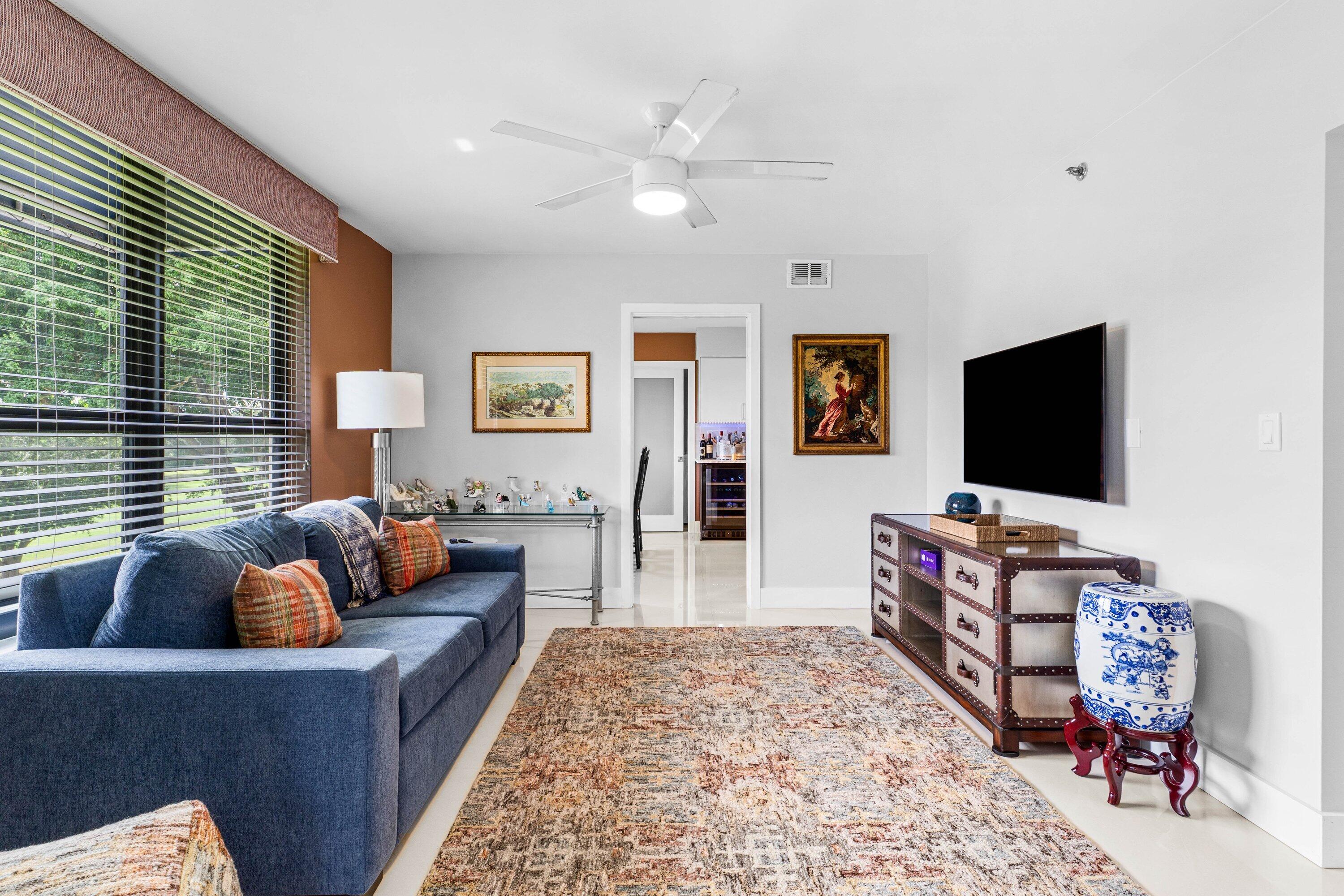 7572 Regency Lake Drive, Unit 301 Boca Raton, FL 33433 - Photo 5 of 38 a living room with furniture and a flat screen tv