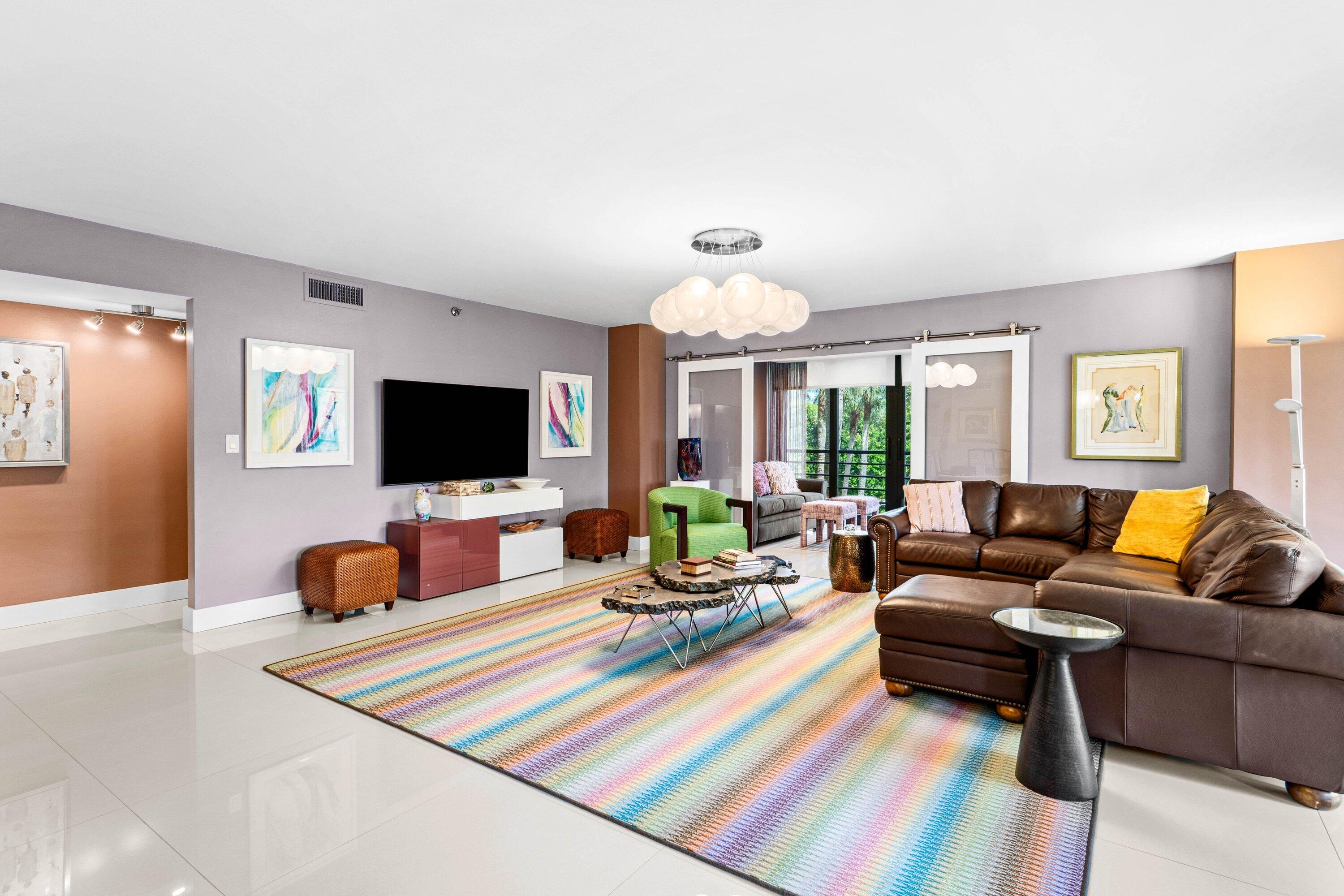 7572 Regency Lake Drive, Unit 301 Boca Raton, FL 33433 - Photo 9 of 38 a living room with furniture and a flat screen tv