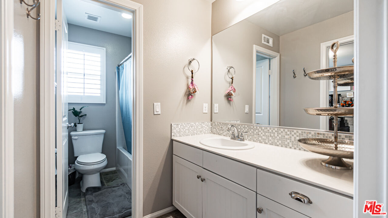 3564 Albion Drive Oxnard, CA 93036 - Photo 22 of 41 a bathroom with a granite countertop sink a toilet and a mirror