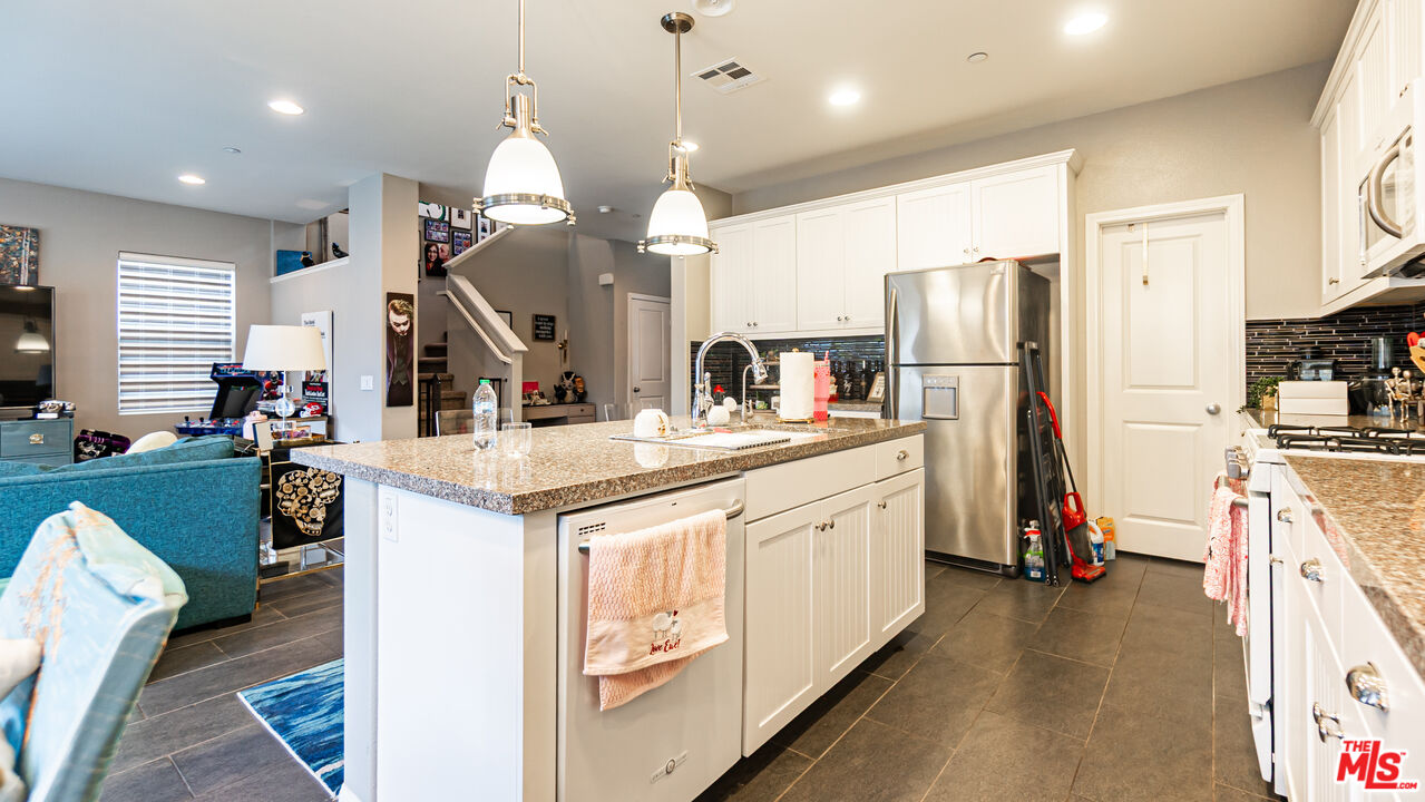 3564 Albion Drive Oxnard, CA 93036 - Photo 7 of 41 a kitchen with stainless steel appliances kitchen island granite countertop a refrigerator a stove a sink and a refrigerator
