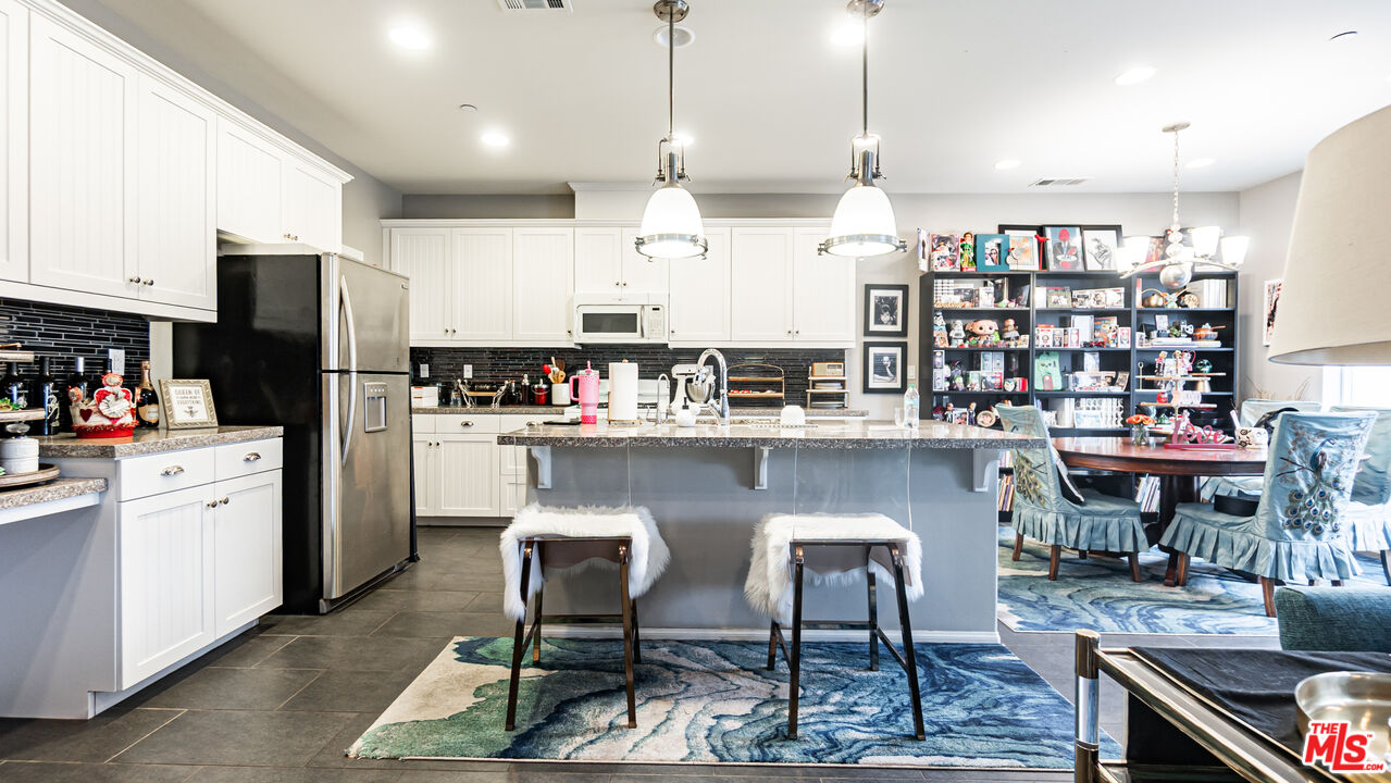 3564 Albion Drive Oxnard, CA 93036 - Photo 10 of 41 a kitchen with stainless steel appliances granite countertop a table chairs and a refrigerator