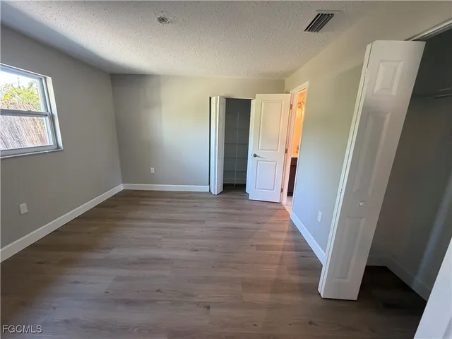 an empty room with wooden floor and a window