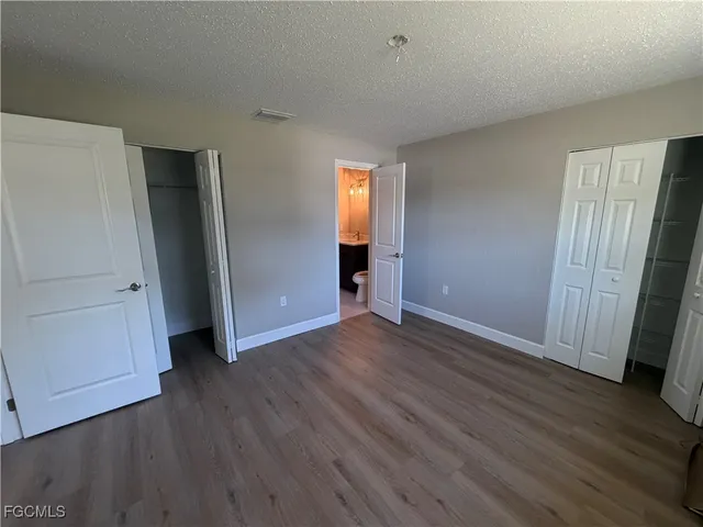an empty room with wooden floor and closet