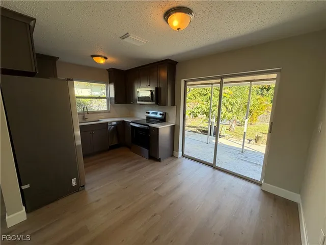 a kitchen with stainless steel appliances granite countertop a stove a sink and a refrigerator