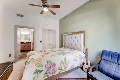 a spacious bedroom with a bed and a chandelier