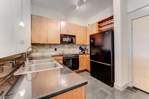 a kitchen with stainless steel appliances granite countertop a refrigerator stove and sink