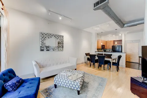 a living room with furniture and wooden floor