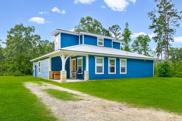 a view of a house with a yard and sitting area