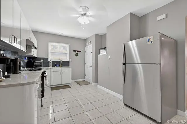 a kitchen with white cabinets and white appliances