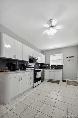 a kitchen with stainless steel appliances a sink a stove top oven a counter space and cabinets