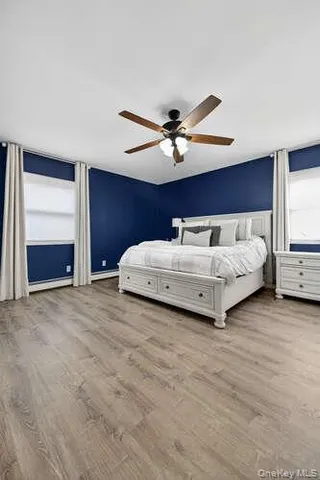 a spacious bedroom with a bed and a ceiling fan