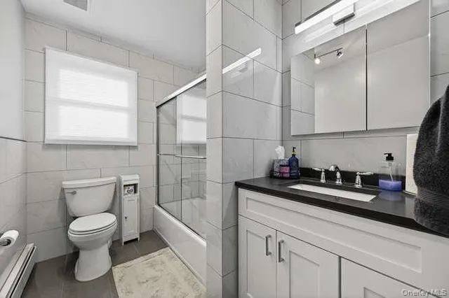 a bathroom with a granite countertop sink a toilet and bathtub