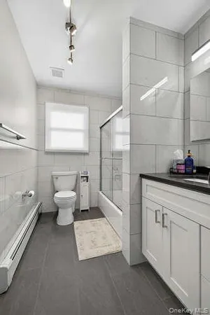 a spacious bathroom with a toilet sink and mirror