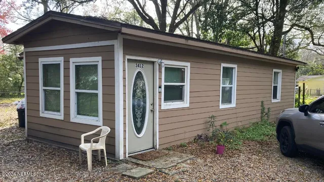 a view of a chair and table in backyard of the house