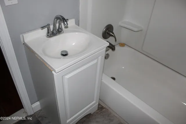 a bathroom with a sink and bathtub with shower