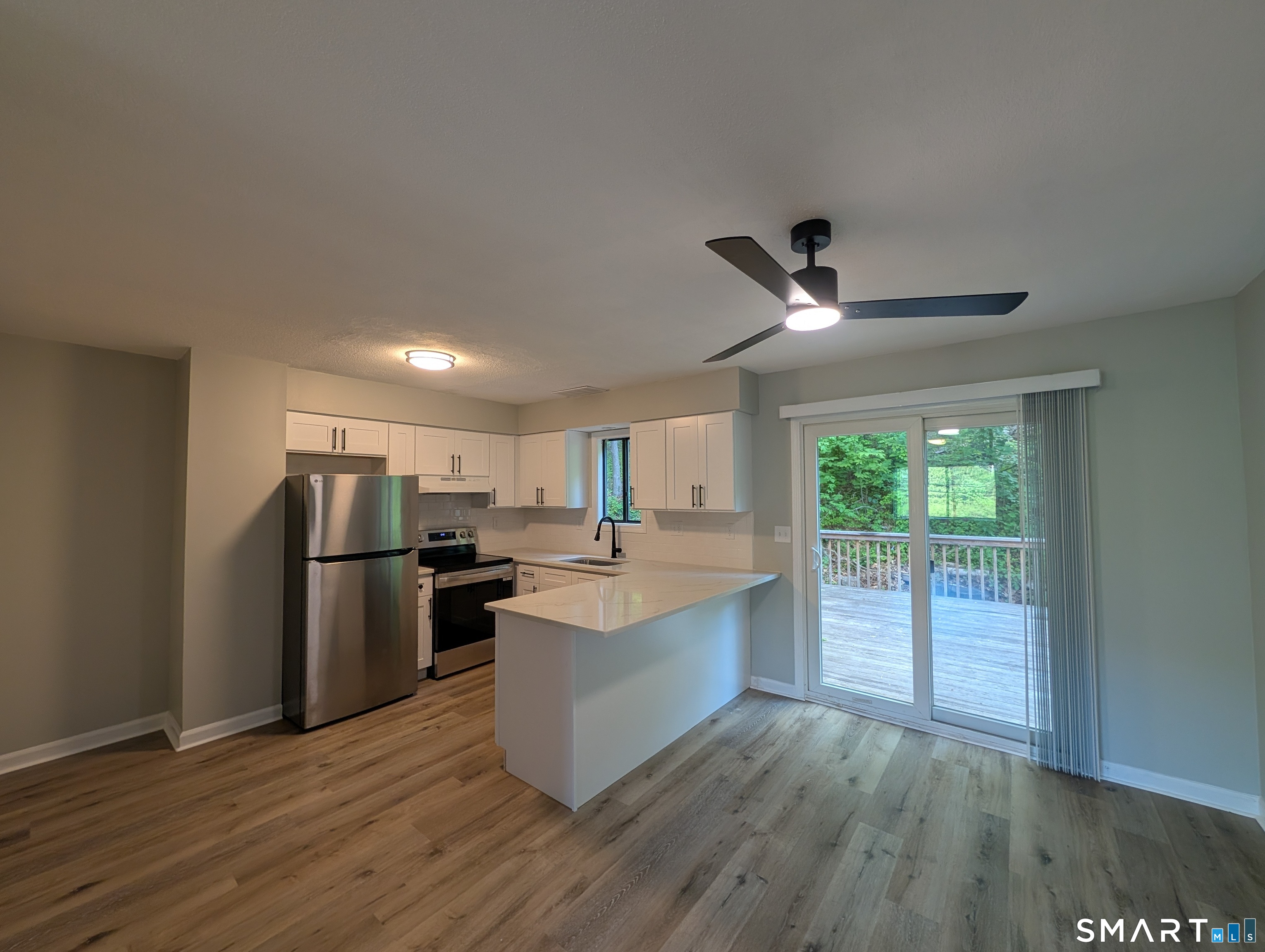 267 Beaver Street Ansonia, CT 06401 - Photo 3 of 12 a kitchen with stainless steel appliances a refrigerator a sink dishwasher a stove and white countertops with wooden floor