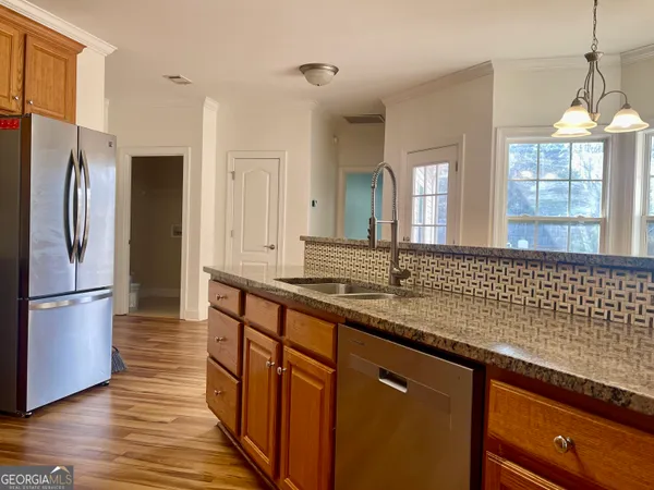 a kitchen with stainless steel appliances granite countertop a refrigerator and a sink