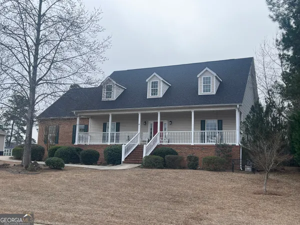 a front view of a house with yard and trees