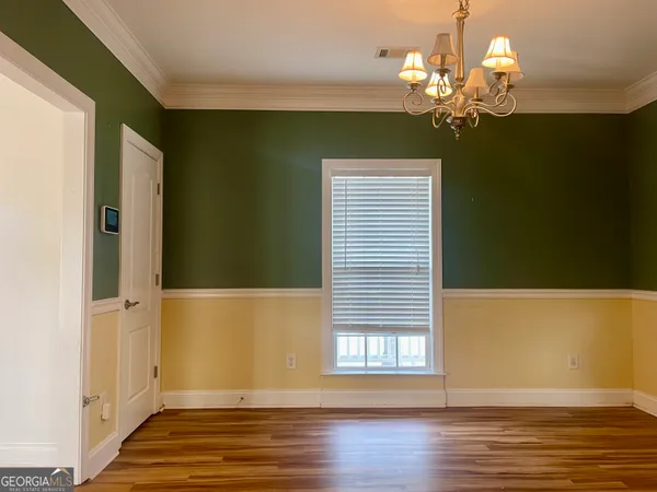 a view of a room with wooden floor and chandelier