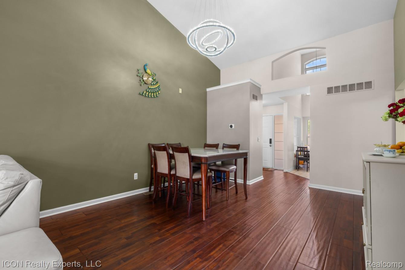 531 Cherry Grove Road Canton, MI 48188 - Photo 10 of 30 Spacious dining area featuring vaulted ceilings, wood-finish flooring, and a contemporary chandelier