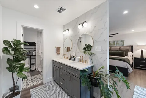 a living room with furniture a potted plant and kitchen view