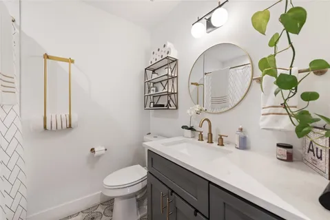 a bathroom with a toilet a sink and mirror