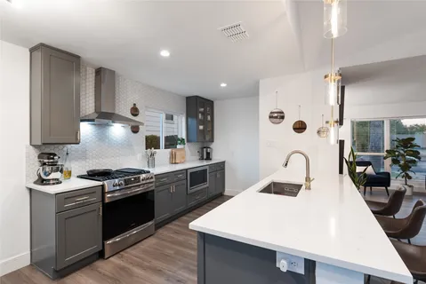 a kitchen with stainless steel appliances a sink stove and refrigerator