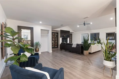 a living room with furniture potted plant and a wooden floor