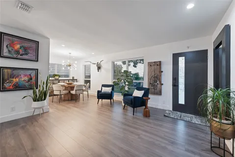 a living room with furniture flat screen tv and wooden floor